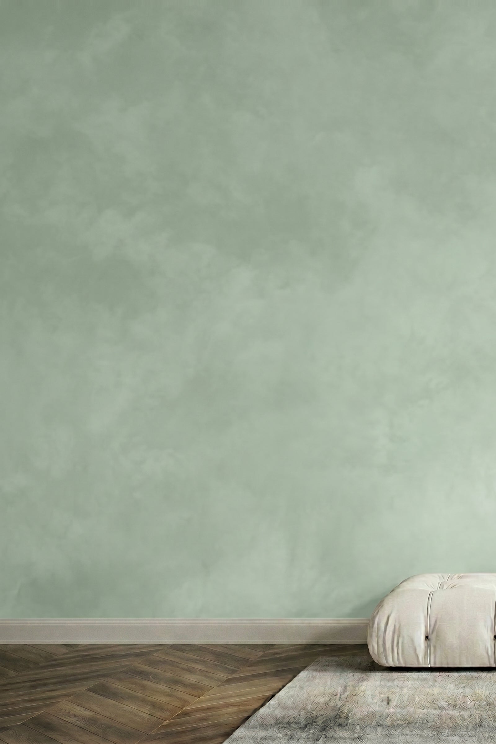Light green limewash wall with a white cushion on a wooden floor